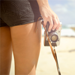 Woman Holdig Vintage Camera On Sunny Beach, relaing holiday